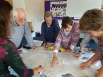 Photo of five people working on a large piece of paper